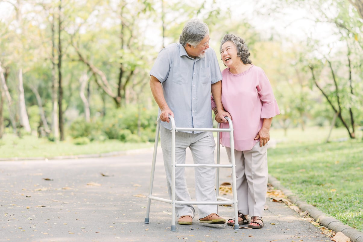 Happy Senior Couple Taking a Walk with Walker